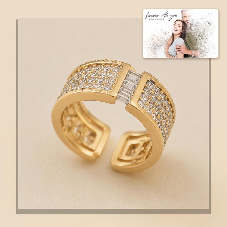 Gold-tone open ring with rows of clear accents, light-bordered product view. A personalized greeting-card example appears in the corner.
