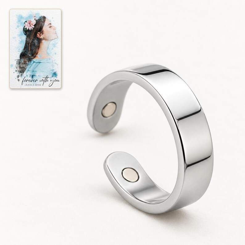 Close detail of the reflective silver-tone ring band and one flush round insert on its inner tip. A personalized digital greeting card is shown alongside.
