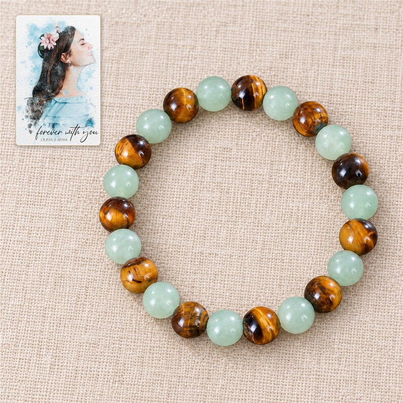 Forest Amber Bead Bracelet arranged on soft ivory linen in a refined neutral flat lay. A personalized digital greeting card is shown alongside.