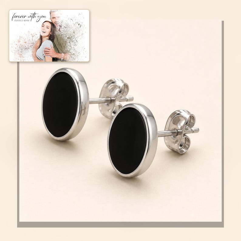 Black oval stud earrings with silver-tone edges, framed product view. A personalized greeting-card example appears in the corner.