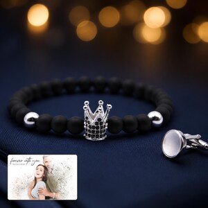Midnight Crown Bead Bracelet arranged on soft ivory linen in a refined neutral flat lay.