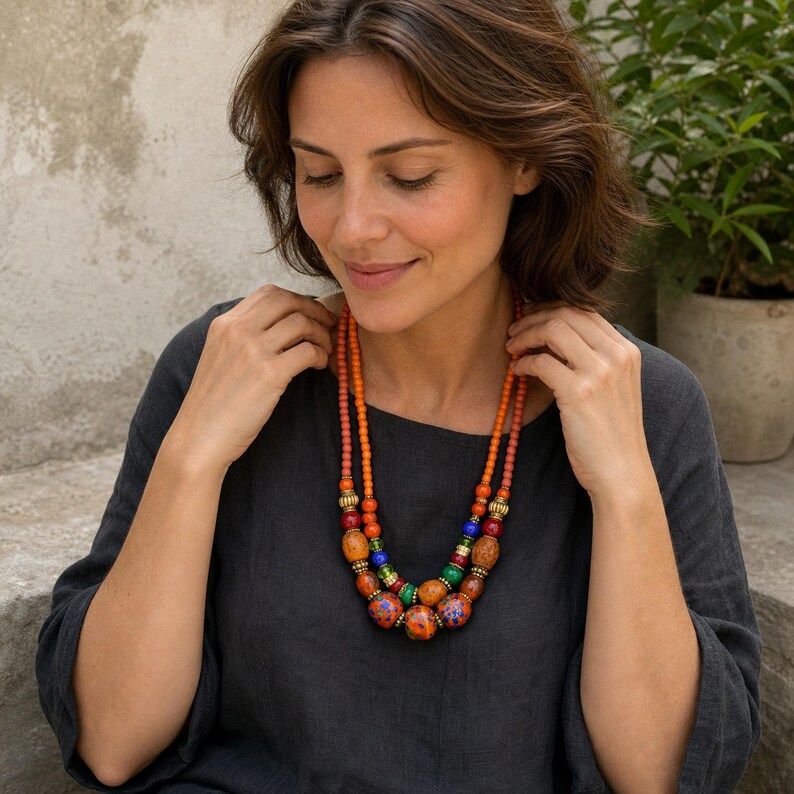 Three-piece handmade necklace set featuring clear and orange beaded necklace, orange and gray beaded necklace and rose gold and gray beaded necklace, displayed together to show the coordinated colors and beadwork