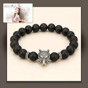 Black bead bracelet with silver-tone wolf-head detail, alternate framed view. A personalized greeting-card example appears in the corner.