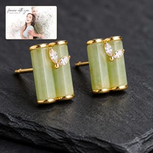 Pale green bamboo-shaped stud earrings with gold-tone edges, dark-bordered product view. A personalized greeting-card example appears in the corner.