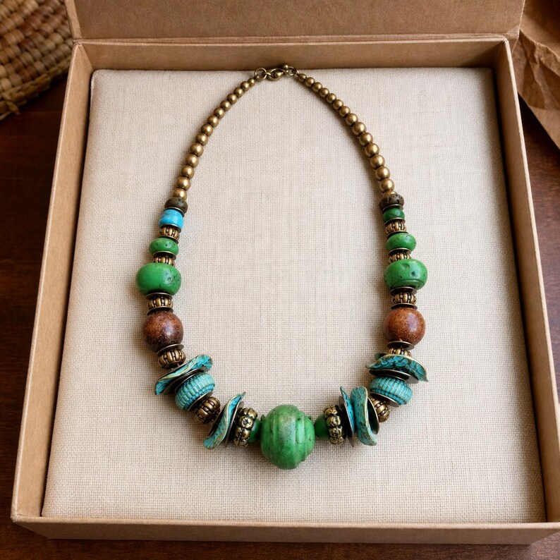Gift ready presentation of Green turquoise and brown artisan statement bead necklace in an open jewelry box lined with natural ivory linen