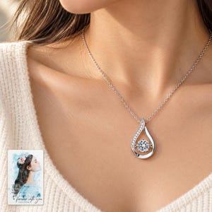Moissanite Teardrop Necklace, worn with daytime clothing. A sample personalized digital greeting card is shown alongside.