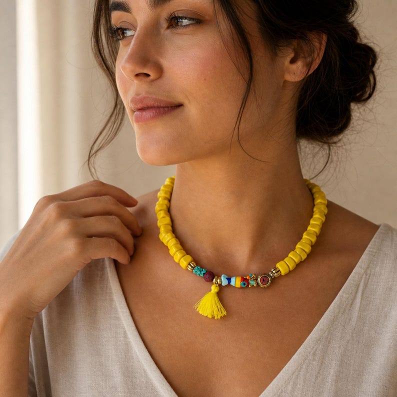 Yellow and Gold Statement Beaded Necklace displayed on a jewelry bust with the layered beadwork and pendants visible