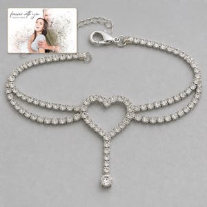 Lovelight Crystal Heart Anklet shown during a warm gift-receiving moment between adults with the exact jewelry visible.