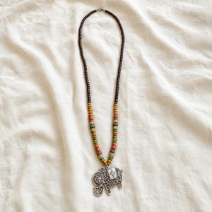 Elephant Pendant Necklace presented in an open jewelry gift box on natural linen