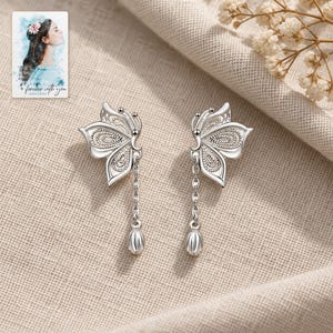 Butterfly Drop Earrings, laid on fabric. A sample personalized digital greeting card is shown alongside.