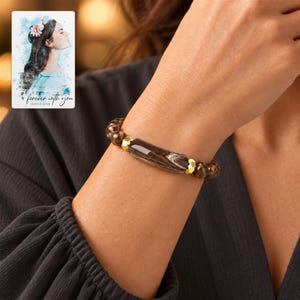 Cocoa Swirl Bar Bracelet worn by an adult in a polished evening lifestyle scene. A personalized digital greeting card is shown alongside.