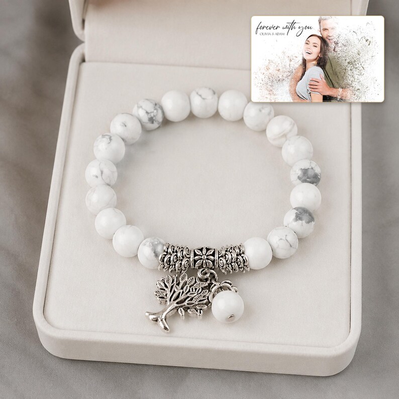 White and gray bead bracelet with silver-tone tree and hanging bead details, presentation in an open jewelry box. A personalized greeting-card example appears in the corner.