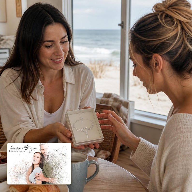 May include: A silver-toned heart-shaped pendant necklace presented in a square white gift box. The necklace features a delicate chain and a central heart charm. A rectangular card is included, displaying a printed photograph of a couple.