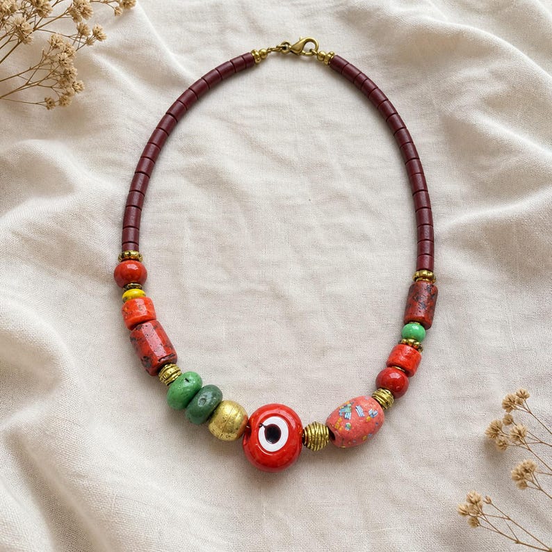 Red Evil Eye Beaded Necklace presented in an open jewelry gift box on natural linen