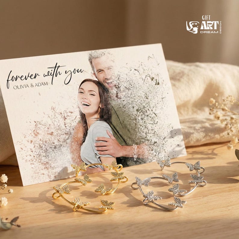 May include: A pair of butterfly ear cuffs, one gold and one silver, sit in front of a card with the words "forever with you" and a photo of a couple. The ear cuffs feature butterfly designs and sparkling details.