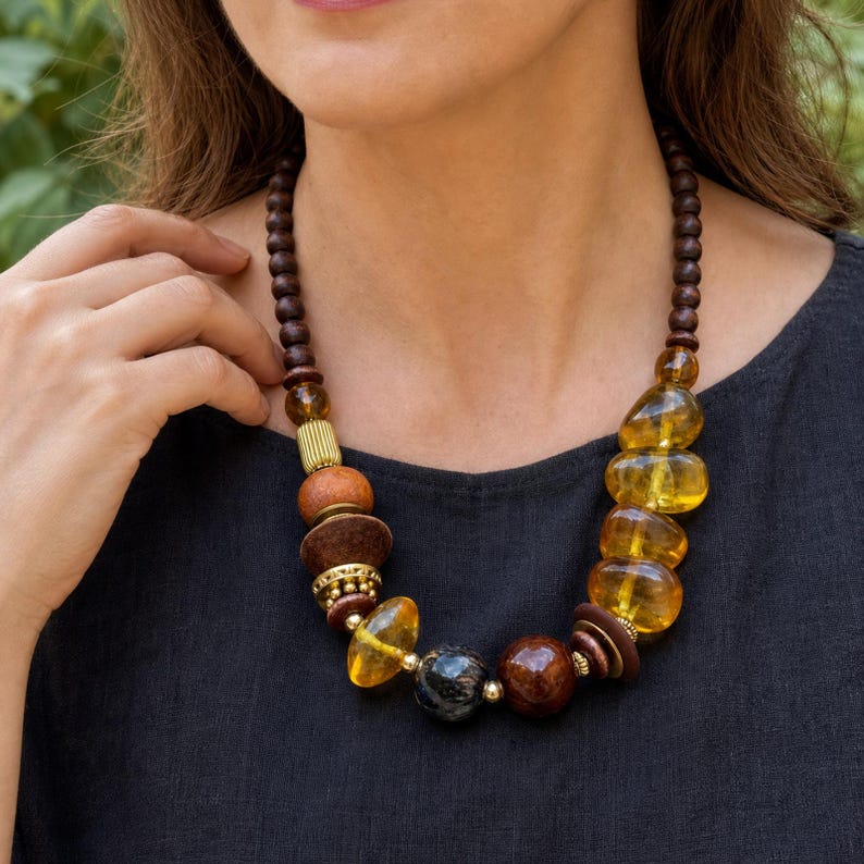 Three-piece handmade necklace set featuring silver and bronze beaded necklace, bronze and beige beaded necklace and orange and silver beaded necklace, displayed together to show the coordinated colors and beadwork