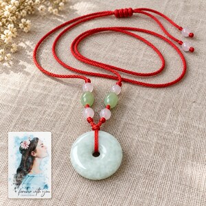 Peace Circle Green Cord Necklace arranged on soft ivory linen in a refined neutral flat lay. A personalized digital greeting card is shown alongside.