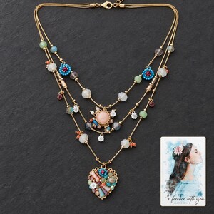 Bohemian Heart Cascade Necklace styled against a dark luxury surface with the exact product finish clearly visible. A personalized digital greeting card is shown alongside.