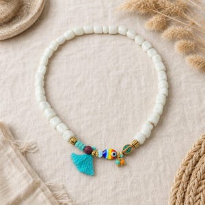 Gift ready presentation of beaded evil-eye necklace in an open jewelry box lined with natural ivory linen