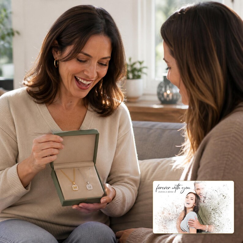 May include: A dark green jewellery box containing two gold-toned necklaces with square pendants, each featuring a letter. Beside the box is a rectangular card with a photo of a couple and the text "forever with you" and "OLIVIA & ADAM".