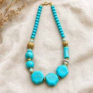 Blue and Silver Statement Beaded Necklace presented in an open jewelry gift box on natural linen