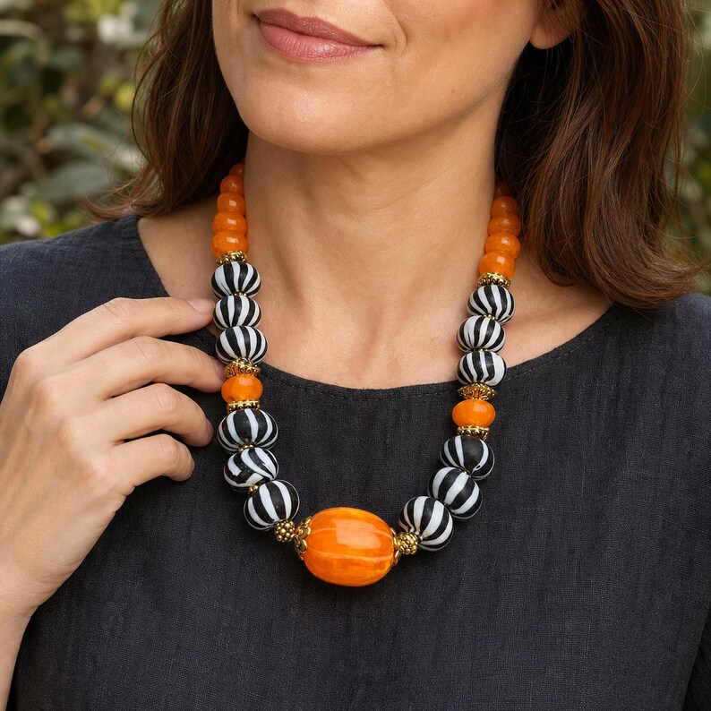 Three-piece handmade necklace set featuring orange and silver beaded necklace, orange and brown beaded necklace and orange and brown beaded necklace, displayed together to show the coordinated colors and beadwork
