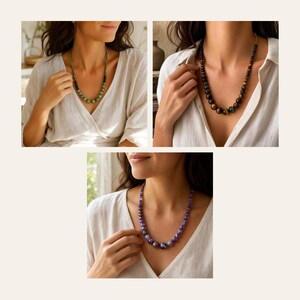May include: A collection of three beaded necklaces featuring round polished stones. One necklace displays green beads, another features brown and gold tiger eye beads, and the third showcases purple amethyst beads, all worn with a white linen shirt.