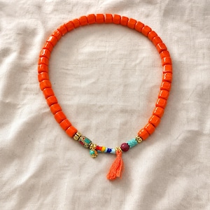 Gift ready presentation of Orange and Red Statement Beaded Necklace in an open jewelry box lined with natural ivory linen