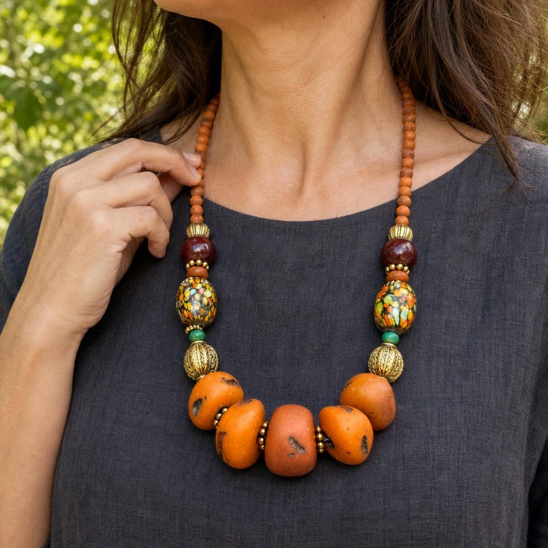 Three-piece handmade necklace set featuring orange and brown beaded necklace, orange and brown beaded necklace and orange and brown beaded necklace, displayed together to show the coordinated colors and beadwork