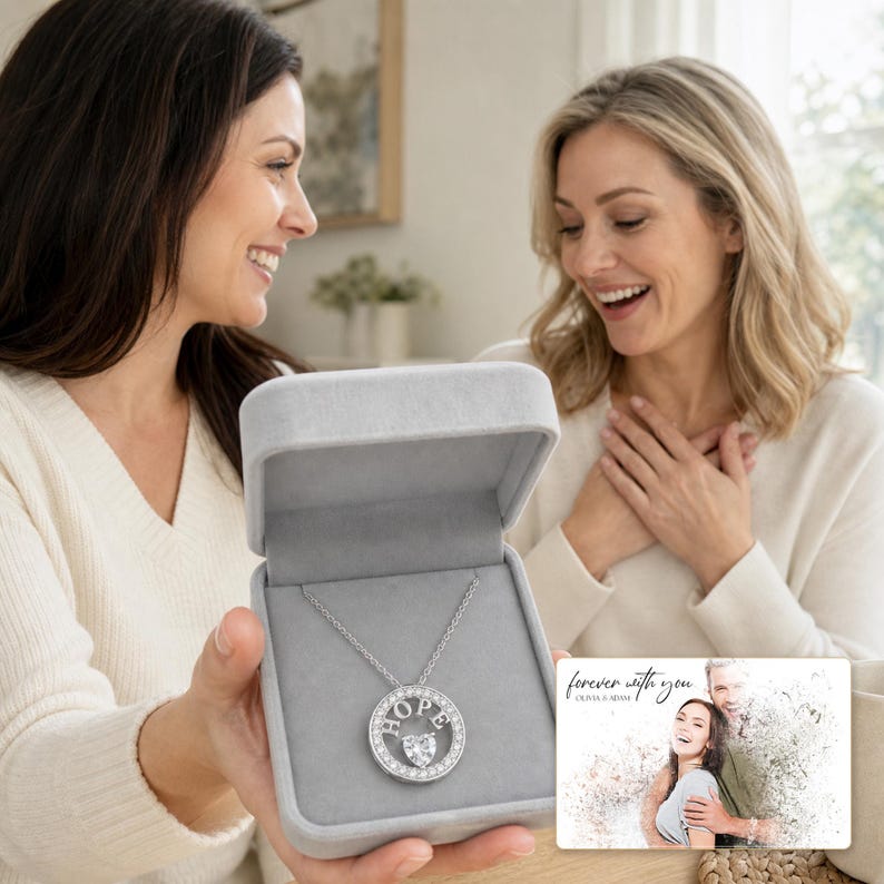 Adult woman receiving the White Gold HOPE necklace in an open jewelry box from another adult woman.