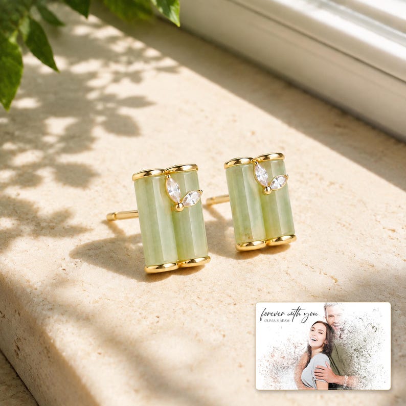 Pale green bamboo-shaped stud earrings with gold-tone edges, light-bordered product view. A personalized greeting-card example appears in the corner.