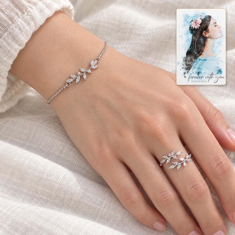 Adult woman wearing the delicate leaf bracelet and matching double-vine ring on her hand against ivory linen. A personalized digital greeting card is shown alongside.