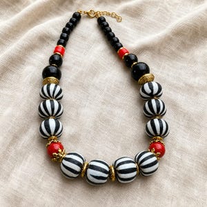Brown and Silver Statement Beaded Necklace presented in an open jewelry gift box on natural linen