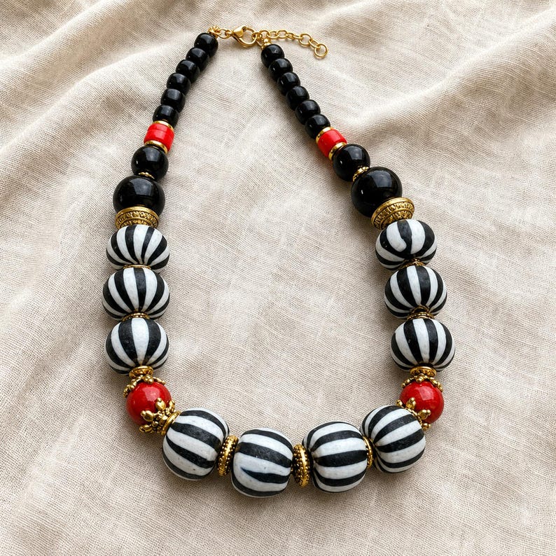 Brown and Silver Statement Beaded Necklace presented in an open jewelry gift box on natural linen