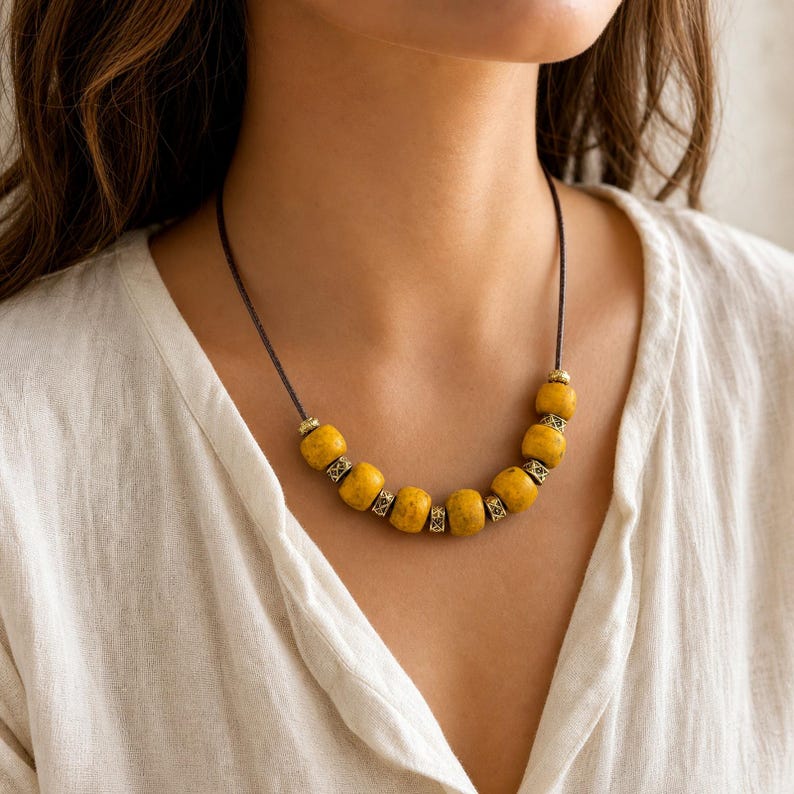 Mustard Yellow Beaded Necklace displayed on a jewelry bust, showing the necklace shape and artisan bead details