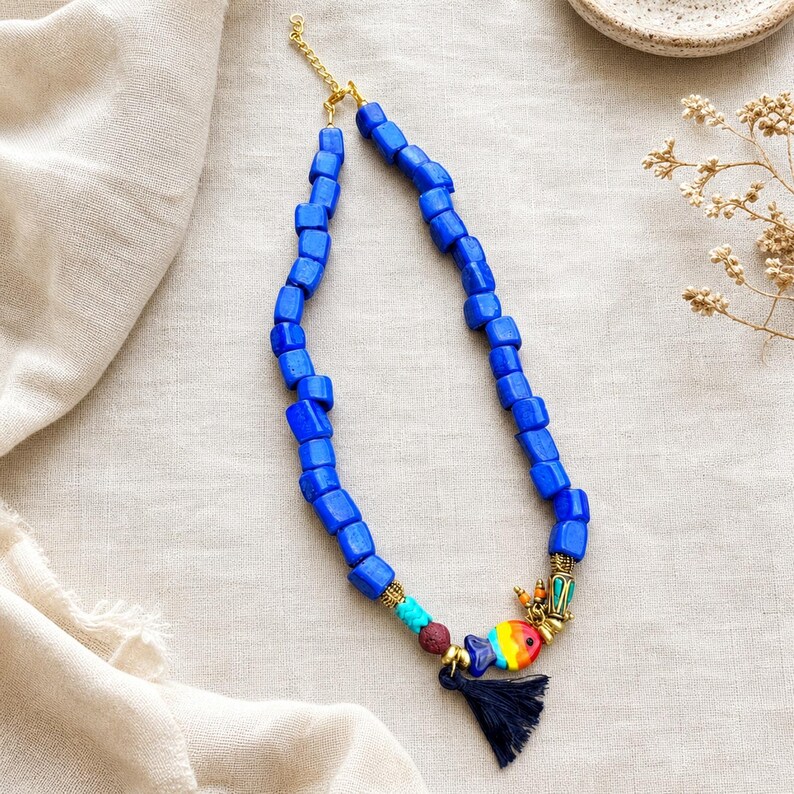 Blue and Clear Statement Beaded Necklace presented in an open jewelry gift box on natural linen