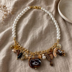 Bronze and Brown Statement Beaded Necklace presented in an open jewelry gift box on natural linen
