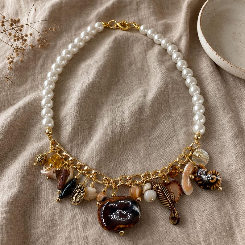 Bronze and Brown Statement Beaded Necklace presented in an open jewelry gift box on natural linen