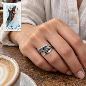 Angel Wings Wrap Ring, worn with daytime clothing. A sample personalized digital greeting card is shown alongside.