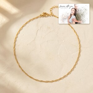 Golden Waterline Chain photographed in warm natural window light in an elegant home setting.