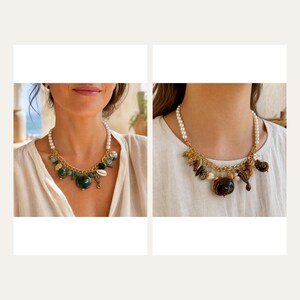 May include: Two necklaces featuring white pearl strands connected to gold-tone chains. The left necklace displays green beads, shells, and sea-themed charms. The right necklace features brown beads, shells, and a seahorse charm, both resting on white fabric.