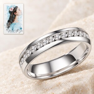 Macro detail of clear round clear accents set in one row between two polished silver-tone edges. A personalized digital greeting card is shown alongside.