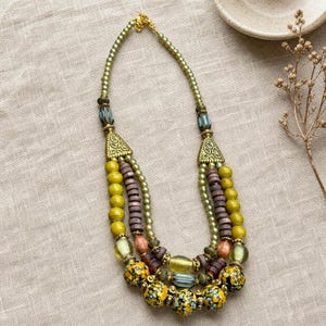 Brown and Bronze Statement Beaded Necklace presented in an open jewelry gift box on natural linen