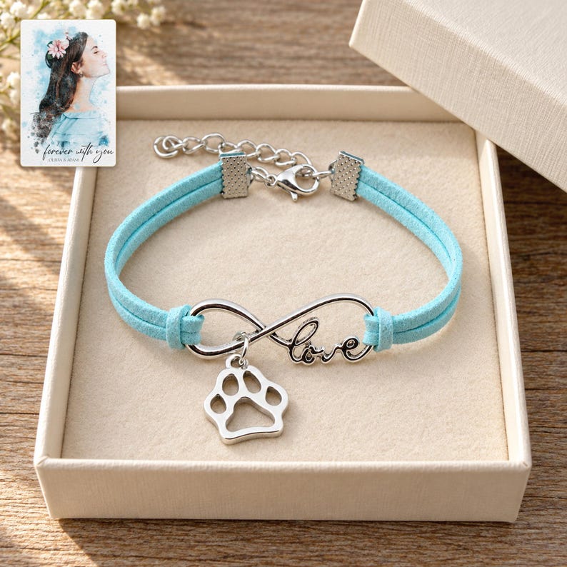 Infinity Love Paw Bracelet, displayed in a presentation box. A sample personalized digital greeting card is shown alongside.