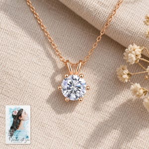 Moissanite Solitaire Necklace, laid on fabric. A sample personalized digital greeting card is shown alongside.