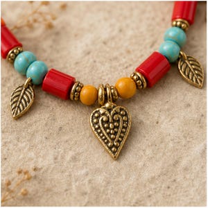 Three-piece handmade necklace set featuring colorful beaded heart charm beaded necklace, antique gold leaf charm beaded necklace and turquoise beaded fish evil eye beaded necklace, displayed together to show the coordinated colors and beadwork