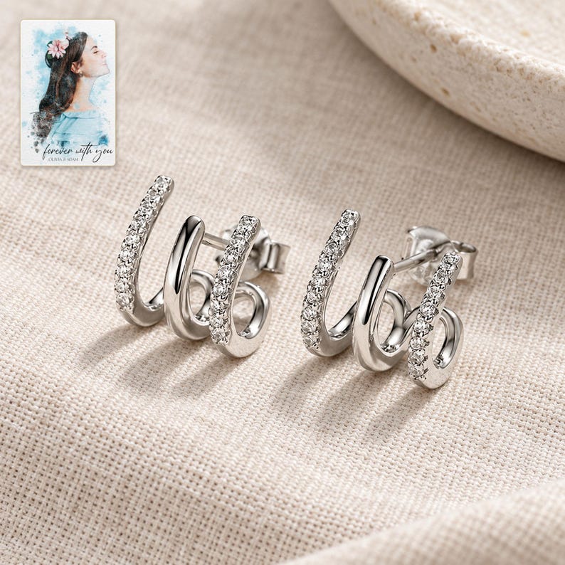 Triple Arc Stud Earrings, laid on fabric. A sample personalized digital greeting card is shown alongside.