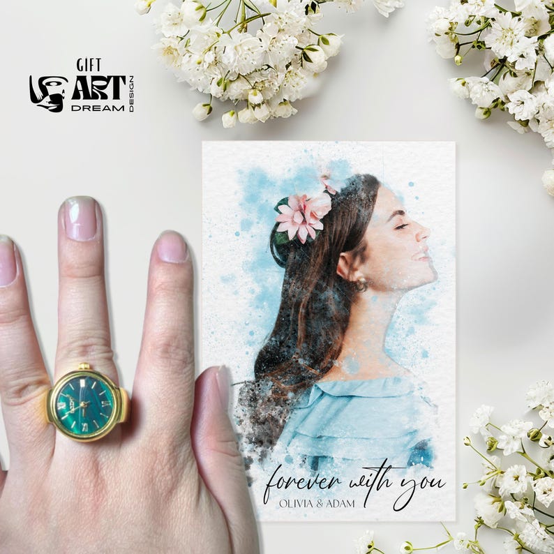 Peut inclure: Une bague-montre dor&eacute;e avec un cadran vert d'eau est pr&eacute;sent&eacute;e &agrave; c&ocirc;t&eacute; d'un portrait &agrave; l'aquarelle d'une femme avec des fleurs dans les cheveux. Le portrait porte l'inscription "forever with you" et les noms "Olivia & Adam". Des fleurs blanches sont en arri&egrave;re-plan.