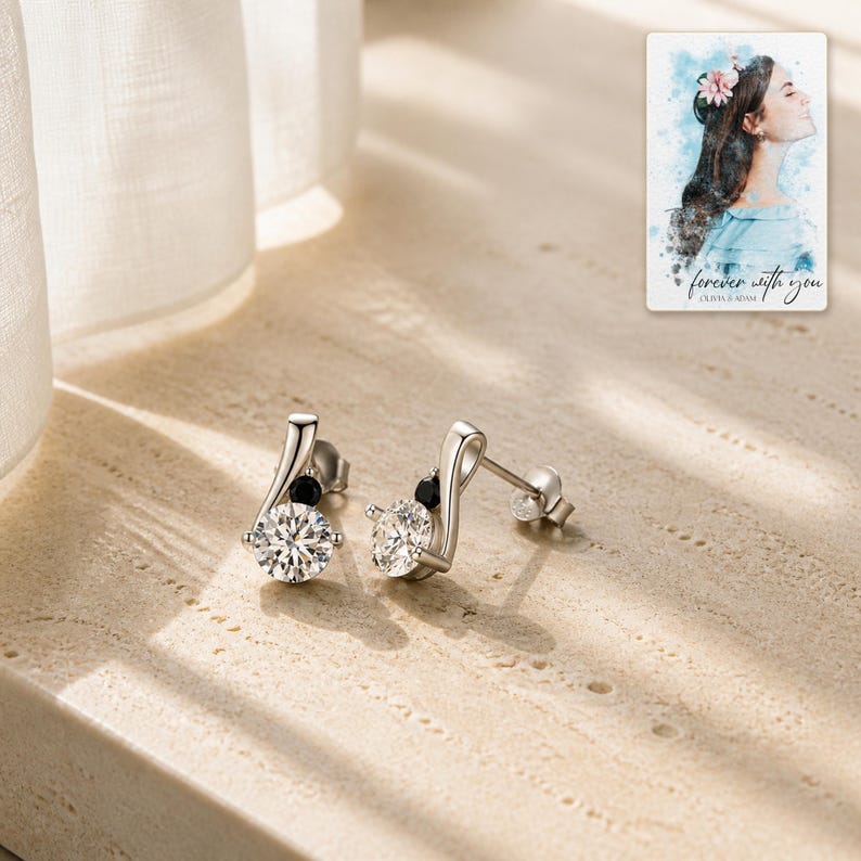 Sterling silver zircon stud earrings arranged on soft ivory linen in a clean neutral flat lay.