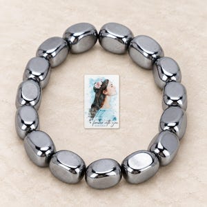 Metallic Grey Bead Bracelet, macro detail view. A personalized digital greeting card is shown alongside.